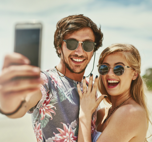 Cleveland couple engaged on the beach taking a selfie with ring purchased at Todd's Jewelers